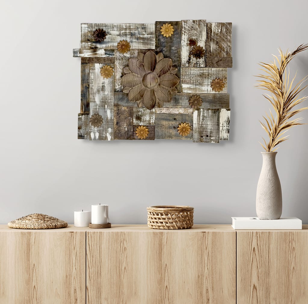Rustic reclaimed wood wall art with carved flowers hanging above a light wood cabinet styled with neutral decor