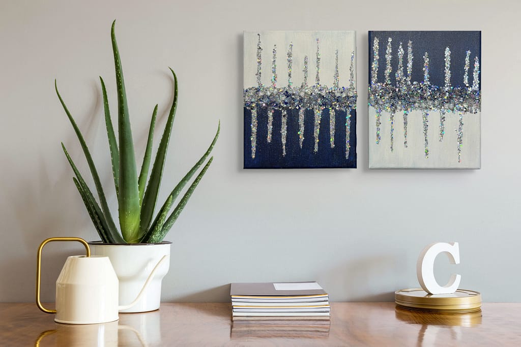 “Crystal Tides” canvases staged with books and indoor plants for a cozy lifestyle setting.