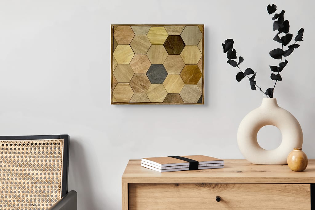 Hexagon wood wall art in mixed wood tones hanging above a wood console with modern ceramic vases and books