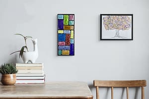 Radiant Mosaic Glow vertical mosaic hanging on a wall beside a colorful tree artwork above a wooden desk