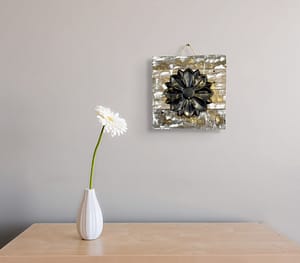 Close-up of a rustic reclaimed wood wall art piece with a single raised flower on a distressed background