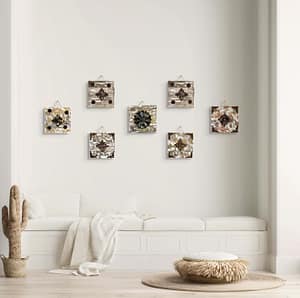 Seven rustic reclaimed wood flower wall art pieces hanging together on a light wall above a couch