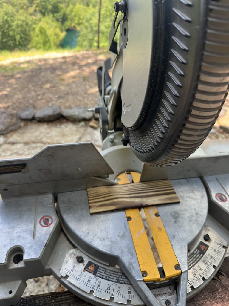 Cutting wood pieces on a miter saw for Shou Sugi Ban geometric wall art.